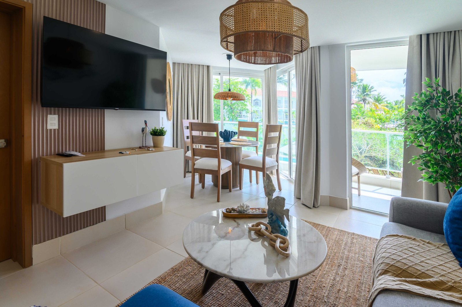 Sala moderna de villa en Puerto Plata con amplios ventanales y vista al jardín.