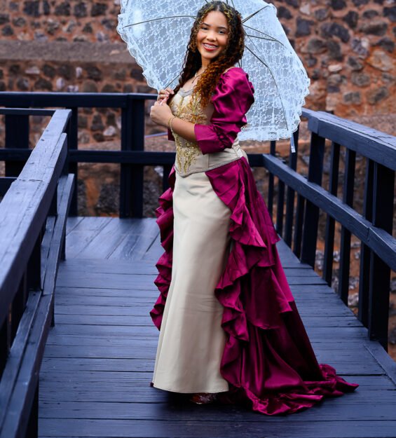 Quinceañera posando junto a los muros históricos de la Fortaleza San Felipe en Puerto Plata.