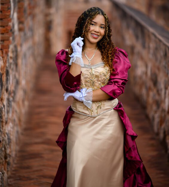Imagen de quinceañera con vestido elegante en escenario colonial de Puerto Plata.